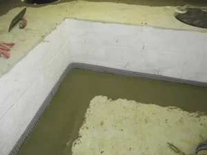 Basement waterproofing system installation with interior drainage and standing water in Newtown PA