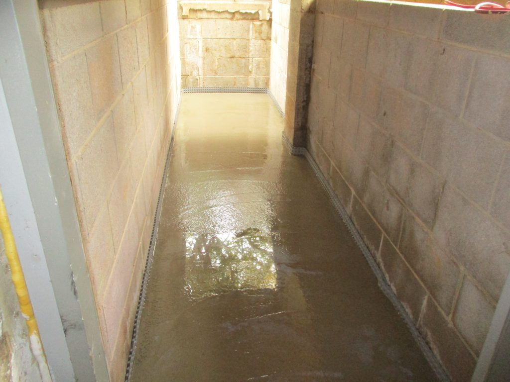 Basement waterproofing system with white vapor barrier and perimeter drainage installed in Lawrenceville NJ