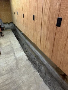 French drain installation process in a basement, showcasing a trench along the foundation wall, prepared for effective water drainage to combat moisture issues in Richboro, PA.