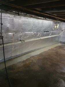 Interior basement drainage system connected to sump pit during waterproofing installation in Newtown PA